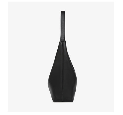 Black pebble-leather tote bag with long shoulder strap, side profile.
