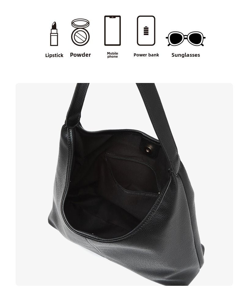Black leather tote bag opened to reveal a spacious interior and inner pocket.