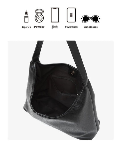 Black leather tote bag opened to reveal a spacious interior and inner pocket.
